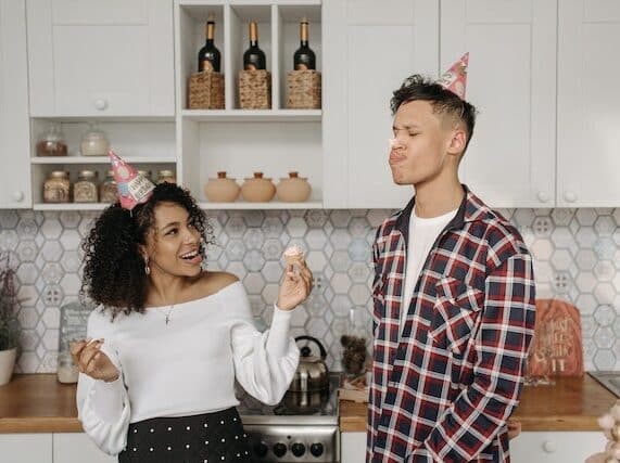 Two teens having fun at a birthday party with a cupcake