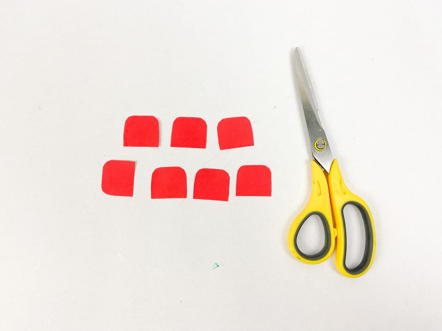 Yellow handled scissors with red cut outs made to look like erasers. 