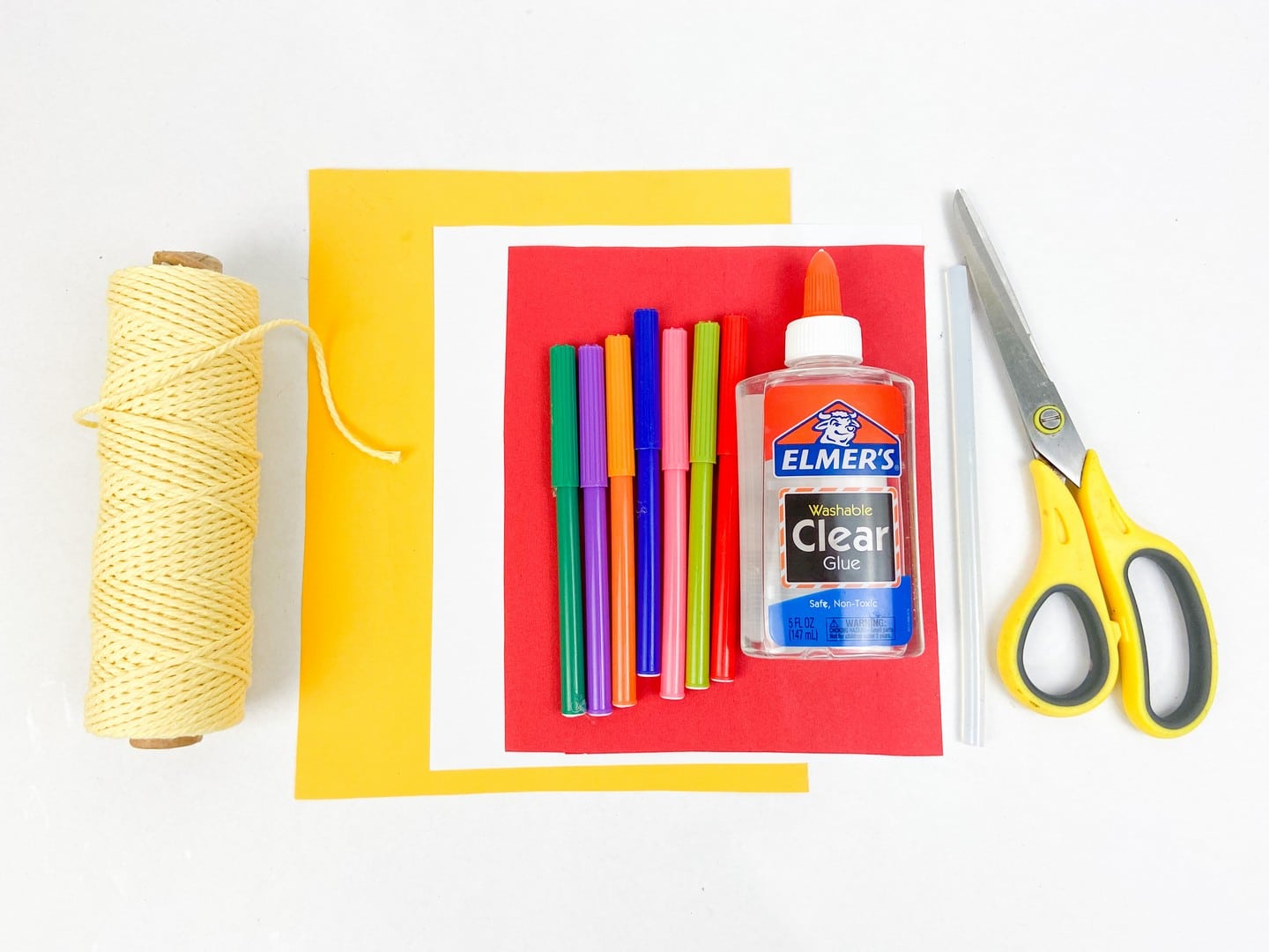 Supplies needed: string, colorful markers, glue, glue stick, yellow handled scissors, and paper in yellow, white, and red. 