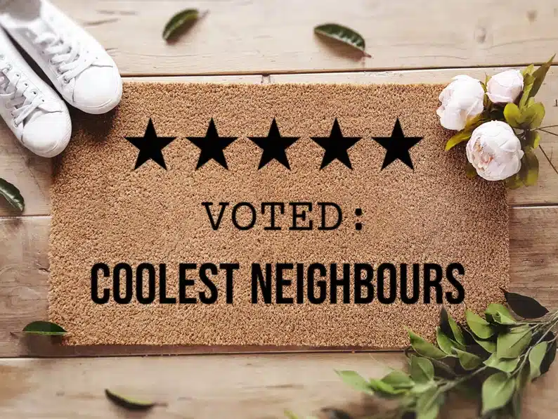 Brown door mat that says five stars voted: coolest neighbors. 