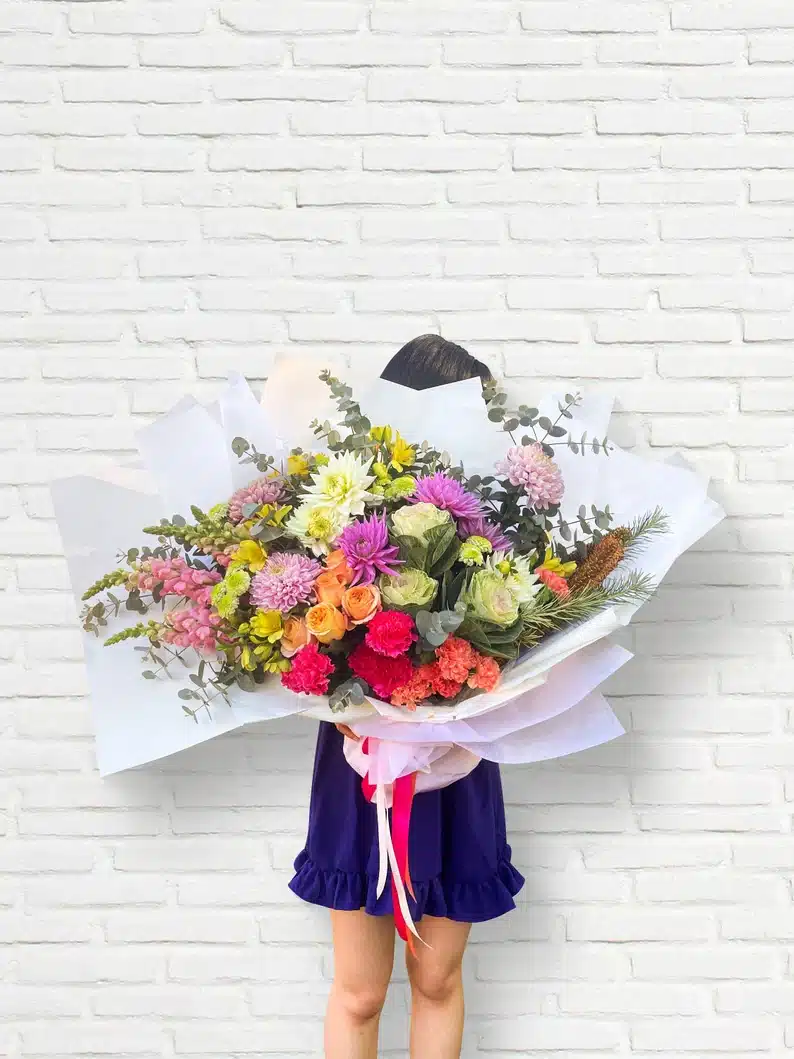 Welcome Gifts for Vacation Rental Guests - Woman holding a giant bouquet of flowers. 