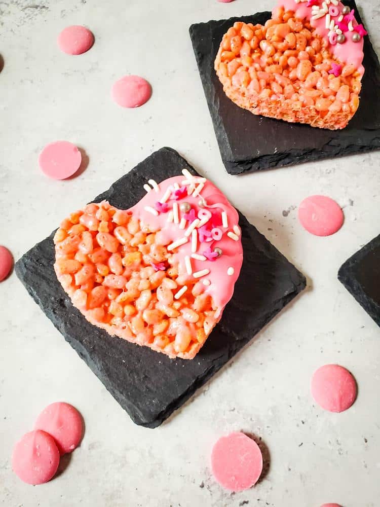 Heart Rice Krispies Treat- close up of pink rice krispes with pink candy melts on it with various sprinkles themed valentines day.