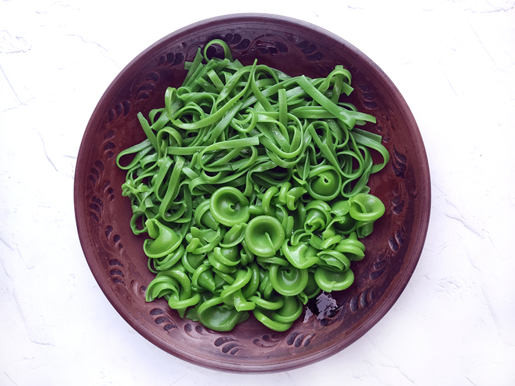 Above view of a purple playe with both types of green pasta in it. 