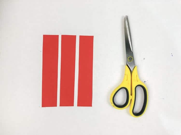 Three red pieces of paper cut into stripes. 