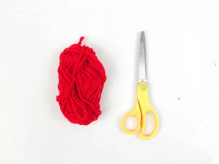 Red yarn with scissors beside it. Patriotic Rocket Craft