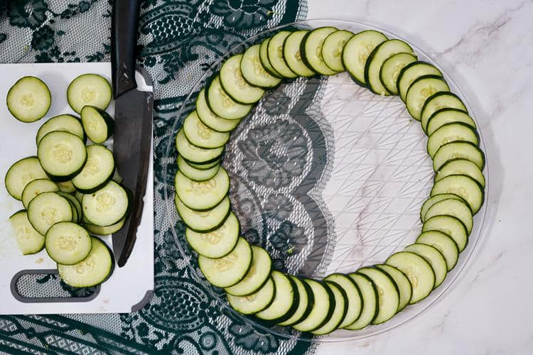 Clear round plate with sliced cucumbers all around forming an outer ring.