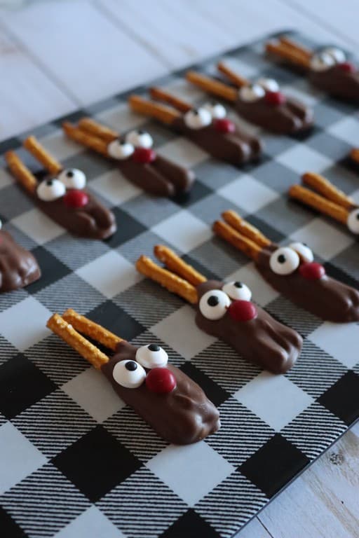 close up of mini pretzel srick reindeers with candy eyes and red mini M&M.