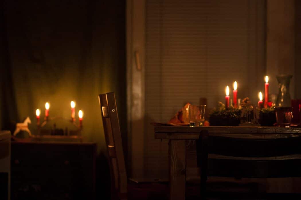 lighted candles on brown wooden table at a romantic valentine's day dinner