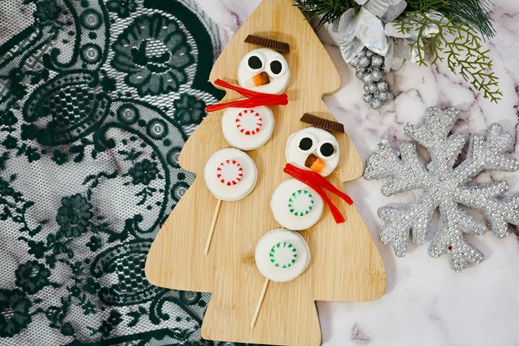 Oreo Snowmen Skewers on a wooden christmas tree cutting board