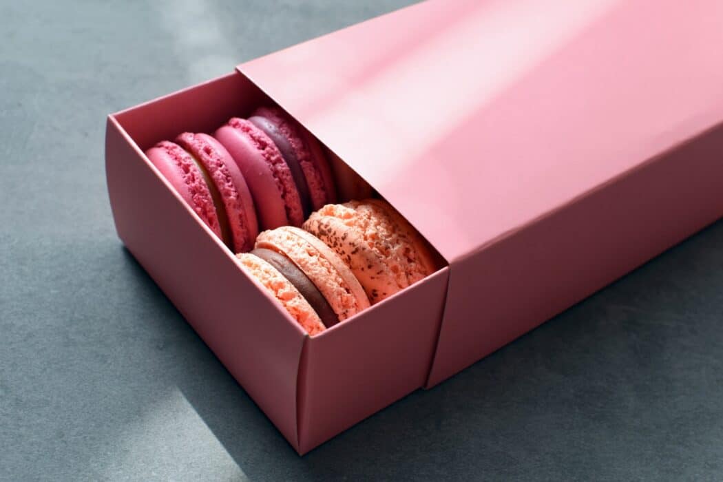 a pink box filled with lots of pink macaroons