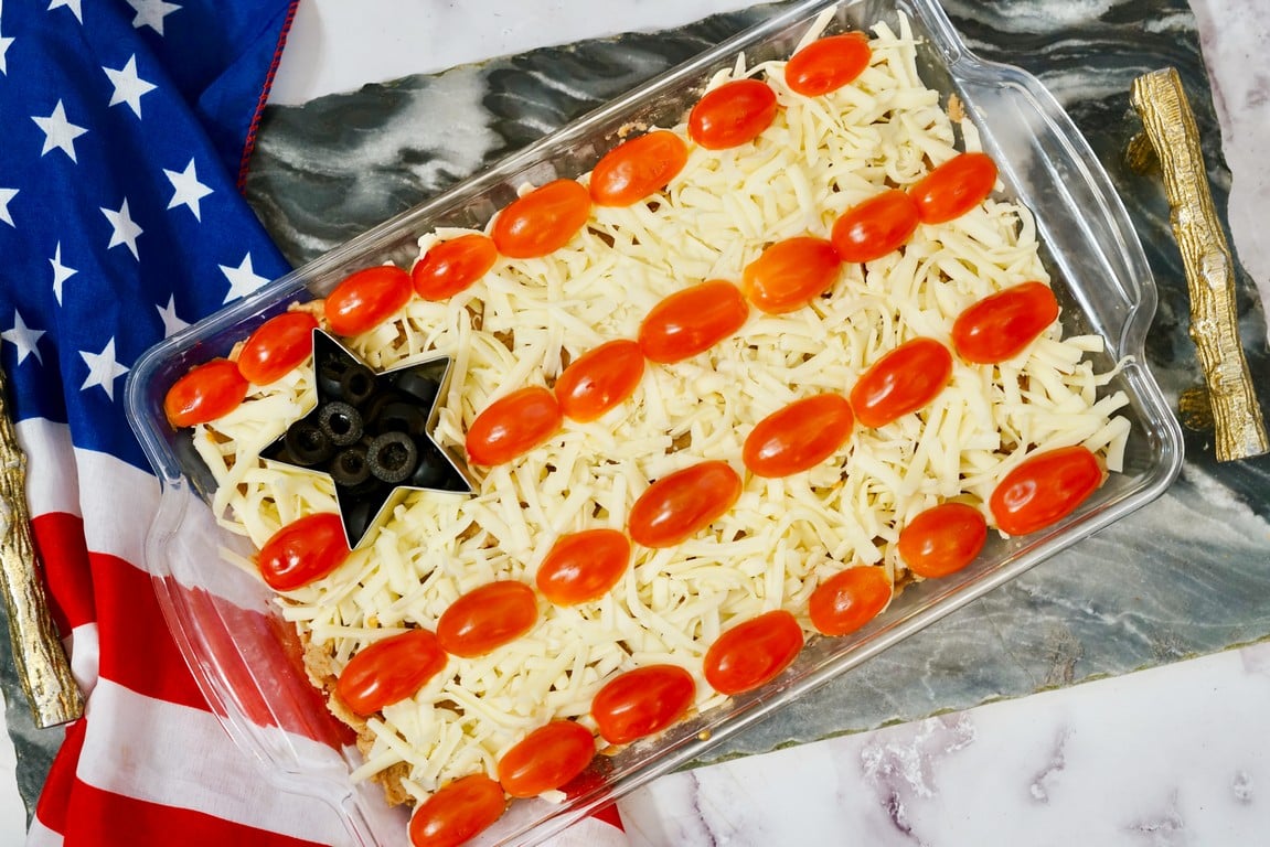 Completed Patriotic Flag Bean Dip with an American flag in the background. 