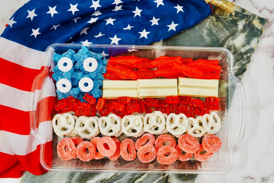 Patriotic Candy Flag in a class cassrole dish with an American flag in the background. 