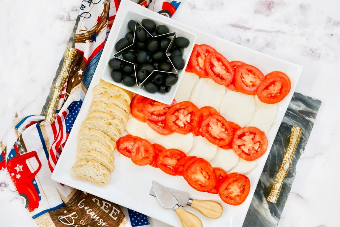 Fresh Mozzarella Patriotic Flag Appetizer - plate with Mozza, cut red tomatoes, bread, and black olives. 